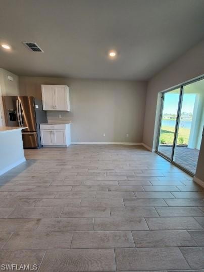 Unfurnished living room featuring visible vents, r