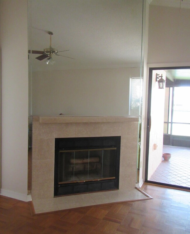 Detailed view of a tile fireplace and a ceiling fan