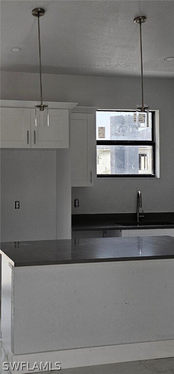 Kitchen with sink, pendant lighting, and white cab