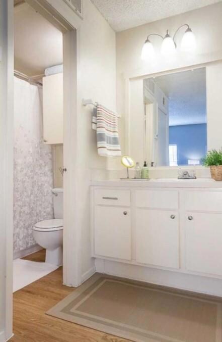 Full bathroom featuring wood finished floors, toi