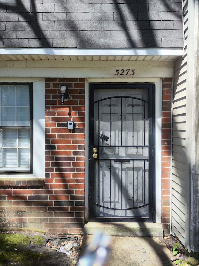View of exterior entry featuring brick siding