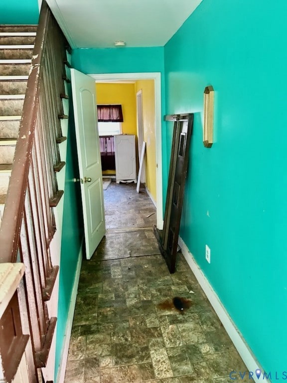 Corridor featuring stone finish flooring and baseboards