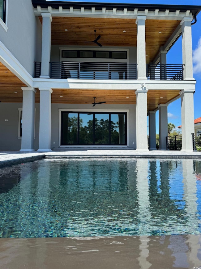 View of swimming pool featuring ceiling fan