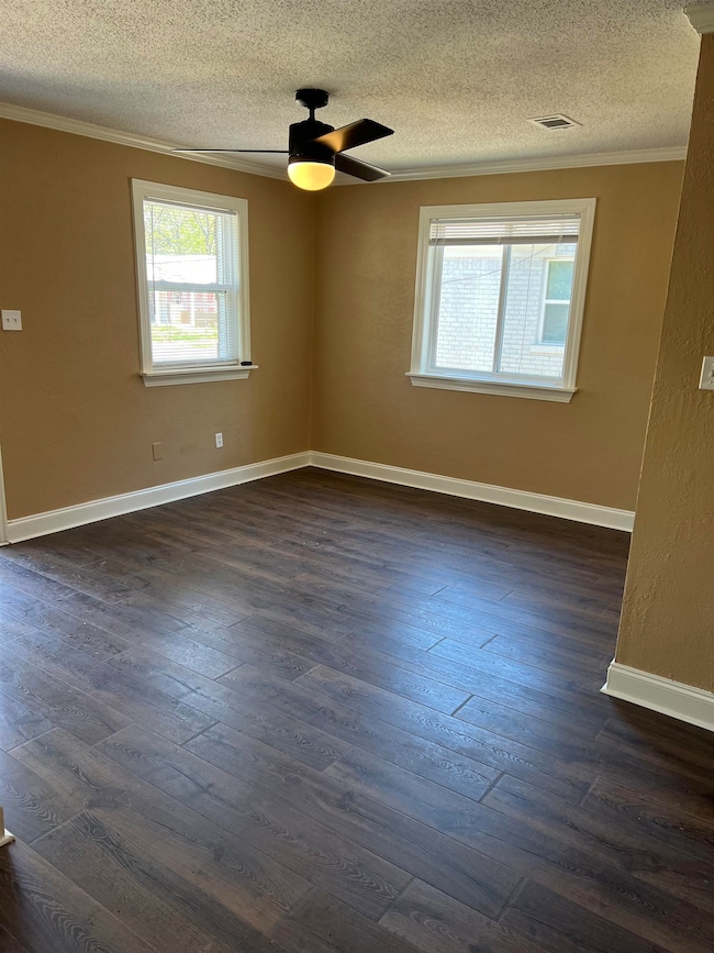 Empty room with ceiling fan, ornamental molding, a