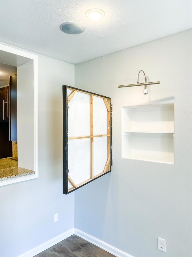 Spare room with baseboards and dark wood-style fl