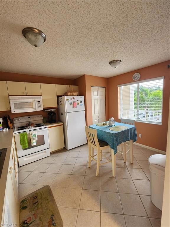 Kitchen with stove, light tile patterned floors, a