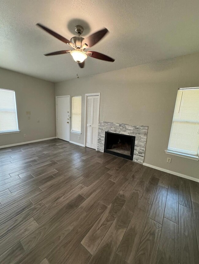 Unfurnished living room featuring a fireplace, ce