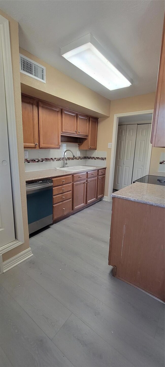 Kitchen with dishwasher, light wood-type flooring,