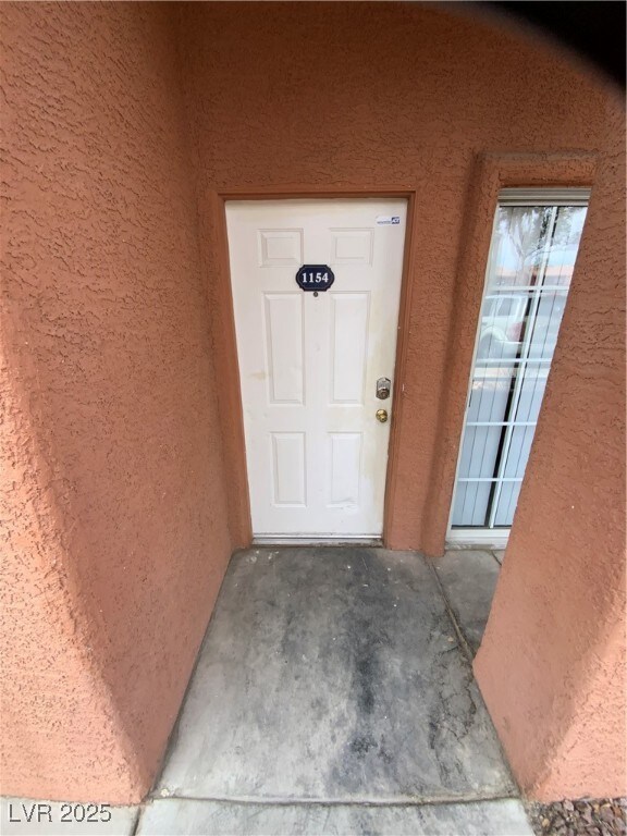 Entrance to property with stucco siding