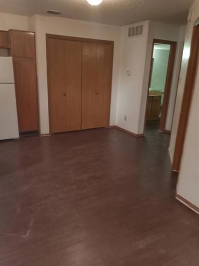 Unfurnished bedroom featuring dark wood-style flo
