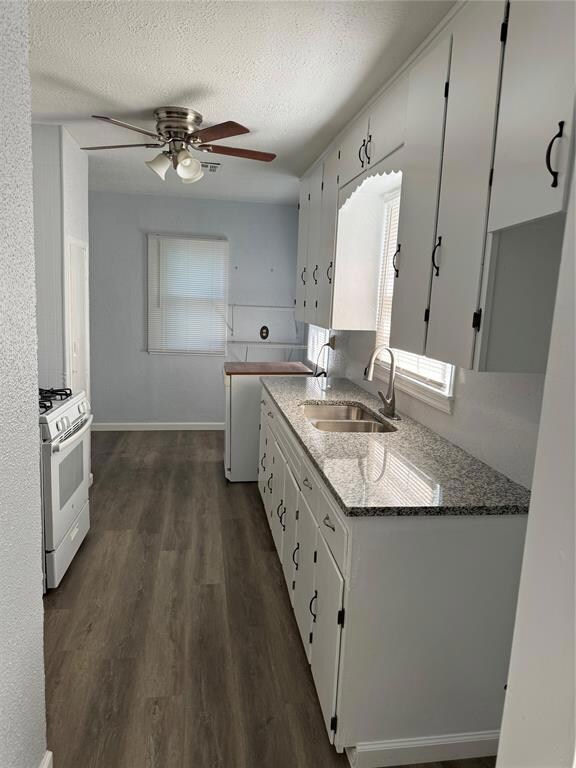 Kitchen with ceiling fan, range, white cabinets, s