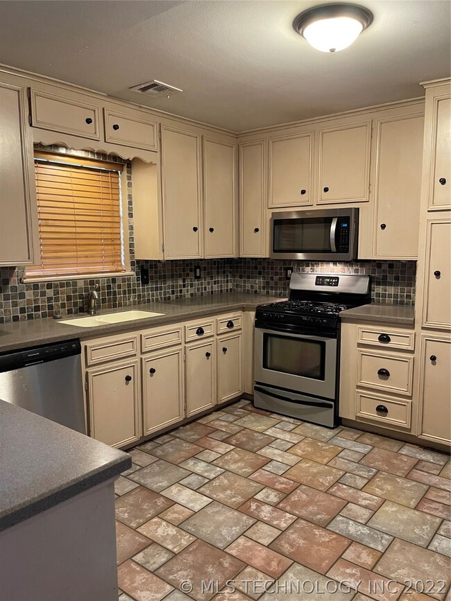 Kitchen has corian countertops, gas stove, and mic