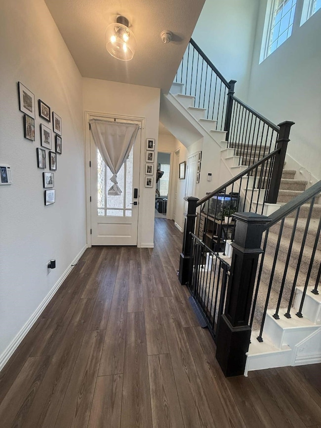 Foyer with dark wood-type flooring and stairway