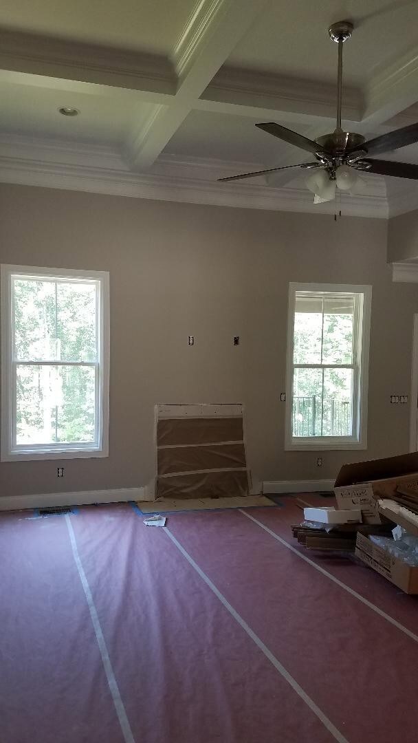 Grand living room with coffered ceiling and one of many fans.  Sand and finish hardwoods in here, too!