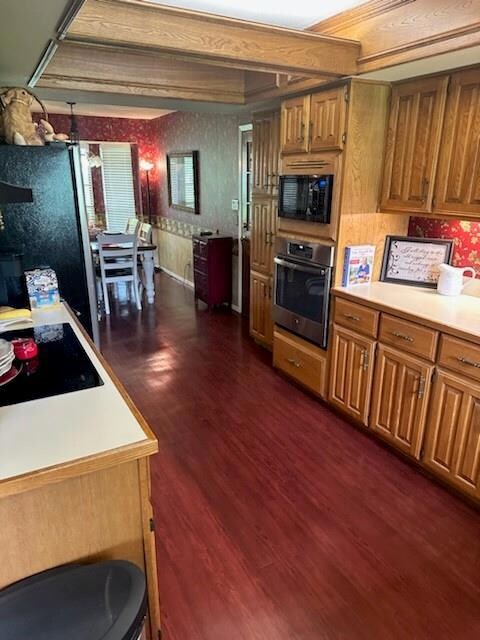 Kitchen with beamed ceiling, black appliances, and