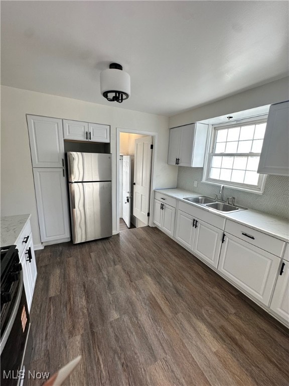 Kitchen with stainless steel appliances, dark wood-style flooring, and white cabinets