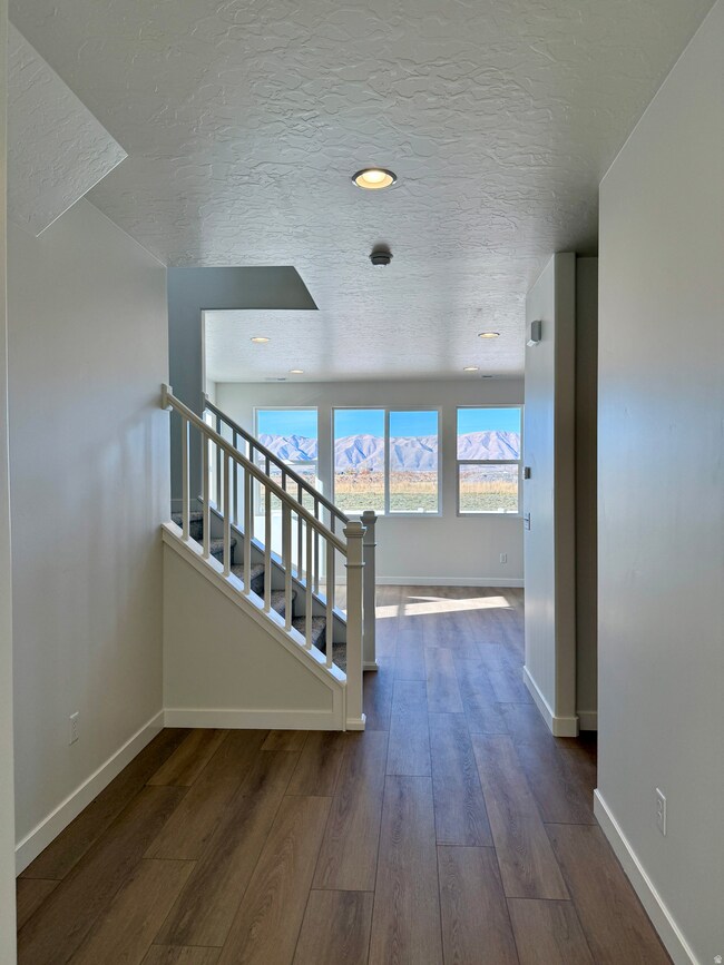 Entry & staircase featuring a textured ceiling, hardwood / wood-style floors, and recessed lighting