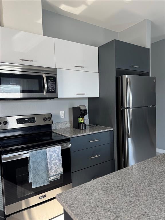 Kitchen with appliances with stainless steel finishes, modern cabinets, and white cabinets