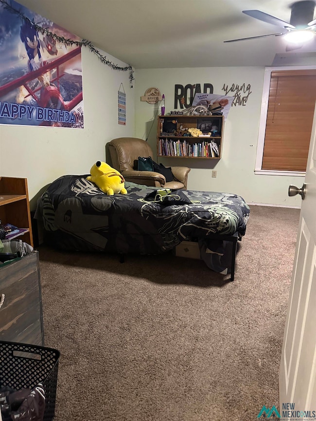 Carpeted bedroom with a ceiling fan