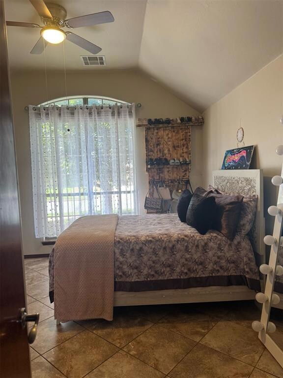 Tiled bedroom with lofted ceiling and ceiling fan