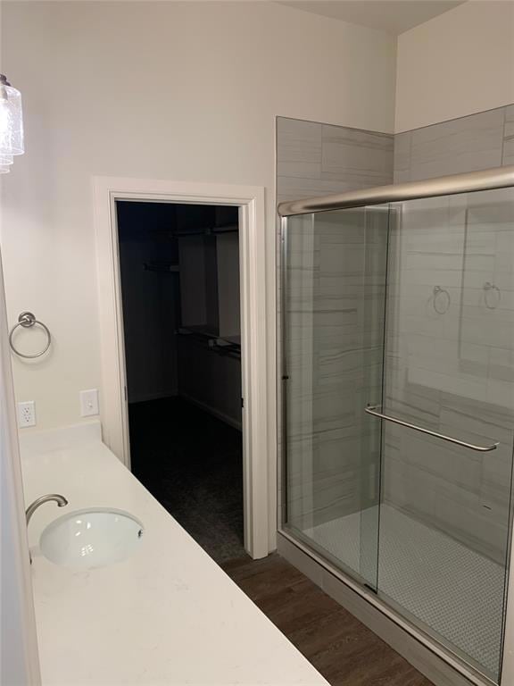 Bathroom featuring a sink, a stall shower, and woo
