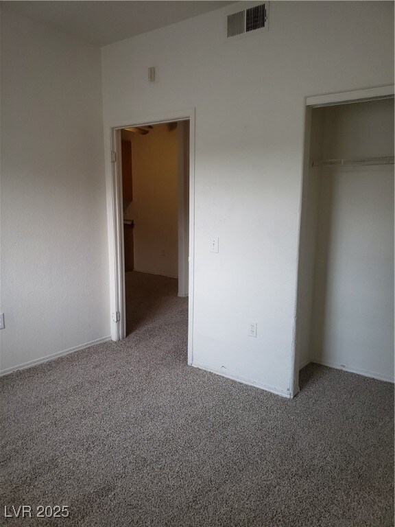 Unfurnished bedroom with carpet floors and a close