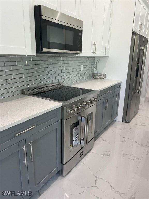 Kitchen featuring white cabinets, decorative backs