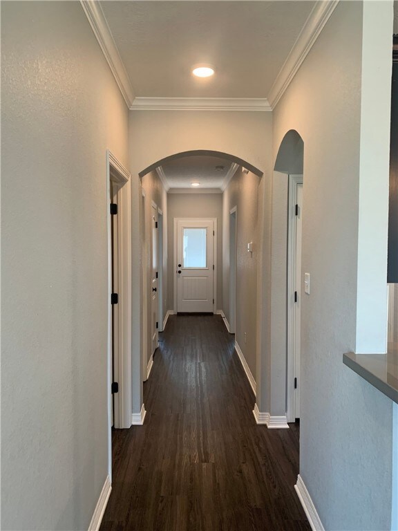 Hall with arched walkways, dark wood finished floo