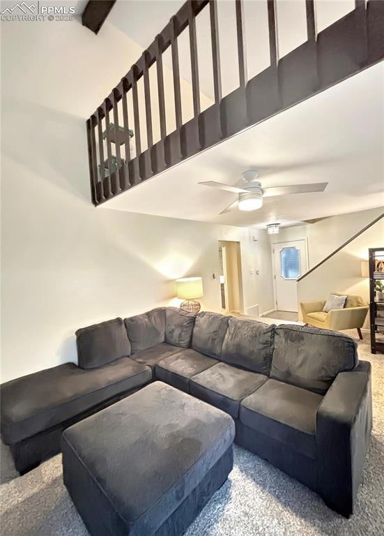 Carpeted living room featuring ceiling fan, high v