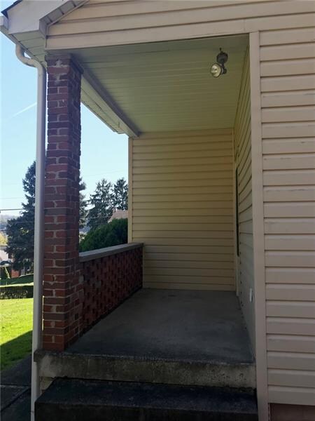 The back porch that leads to a concrete pad that i
