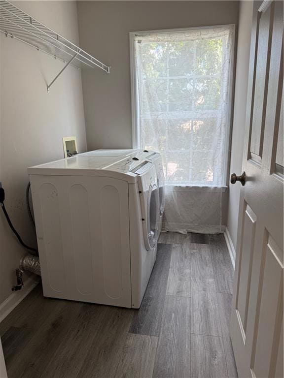 Laundry room featuring wood finished floors and washer and clothes dryer