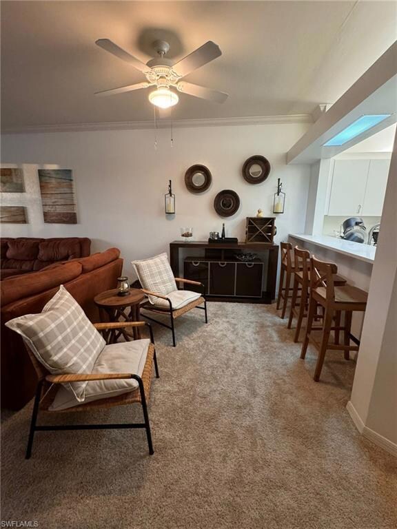Carpeted living room featuring ornamental molding 
