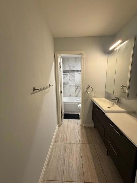 Full bathroom featuring vanity, toilet, and shower