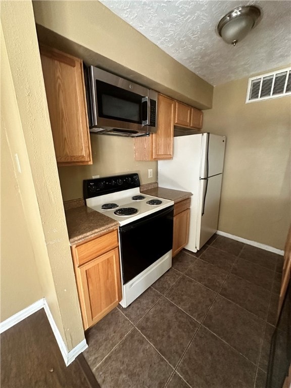 Kitchen with a textured ceiling, visible vents, ba