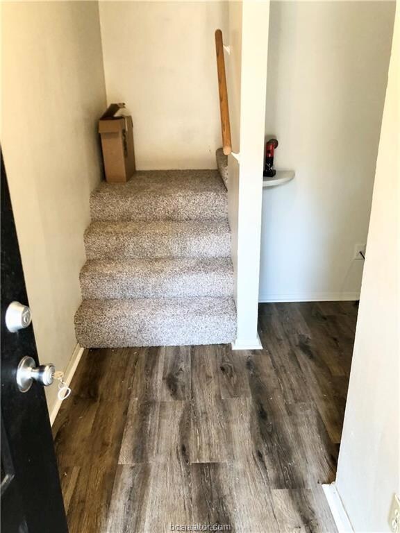Staircase featuring wood finished floors