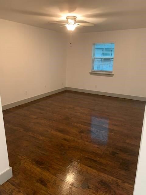 Spare room featuring ceiling fan and dark hardwood