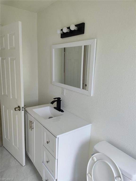Half bathroom featuring vanity and tile patterned flooring