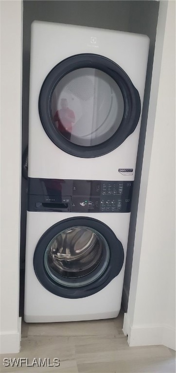 Clothes washing area with baseboards, stacked wash