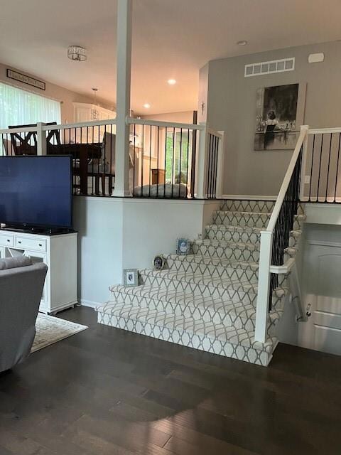 Stairway featuring vaulted ceiling and wood-type flooring