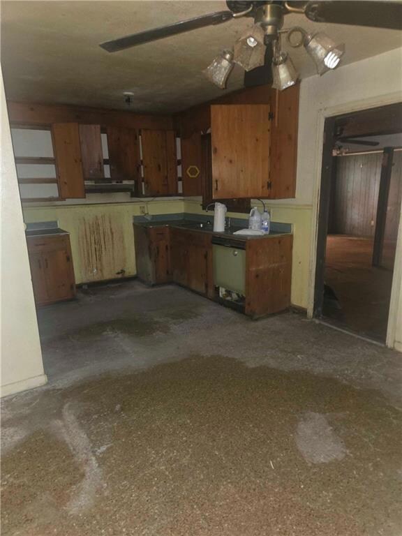 Kitchen with brown cabinetry, a ceiling fan, and dishwashing machine