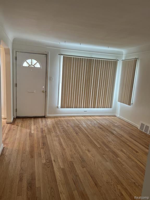 Foyer entrance with light wood-style flooring and baseboards