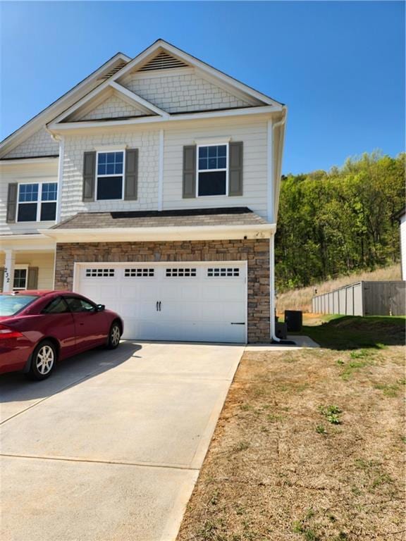 View of front of property featuring driveway, a ga