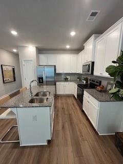 Kitchen featuring fridge, range, a sink, dark wood-type flooring, and recessed lighting