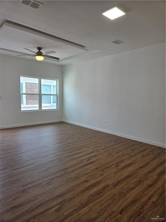 Spare room with baseboards, ceiling fan, visible vents, and dark wood finished floors