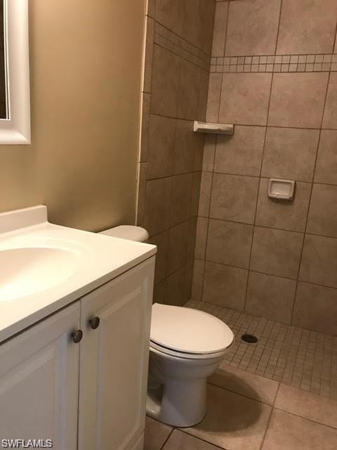 Full bath with vanity, a shower stall, toilet, and tile patterned flooring