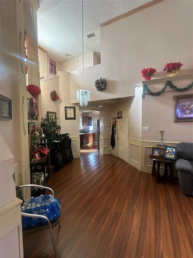Living room featuring high vaulted ceiling, dark h
