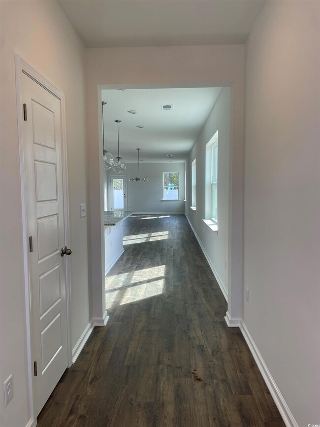 Hall featuring baseboards, visible vents, and dark
