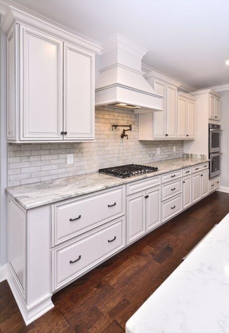 5 Burner Gas Cook-top underneath a Beautiful Decorative Vent Hood.   Photos are from a different Community Model but Similar Floor-plan.