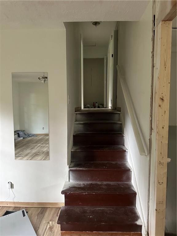 Staircase featuring hardwood / wood-style flooring