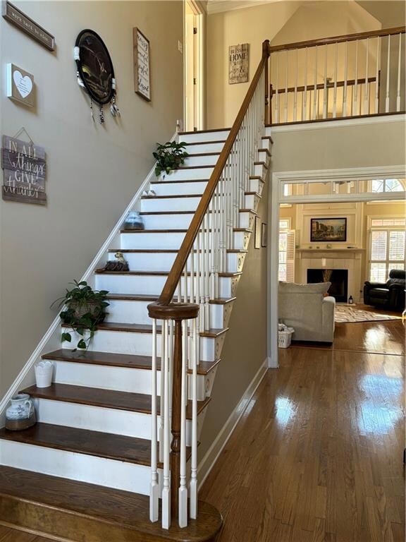 Staircase featuring a towering ceiling and dark wo